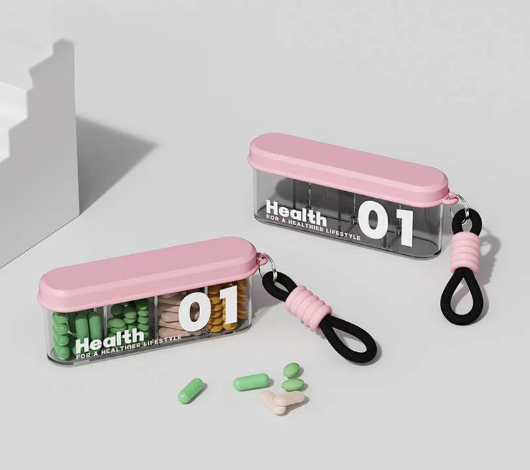 Portable travel pill organizer with four compartments and a carrying strap.