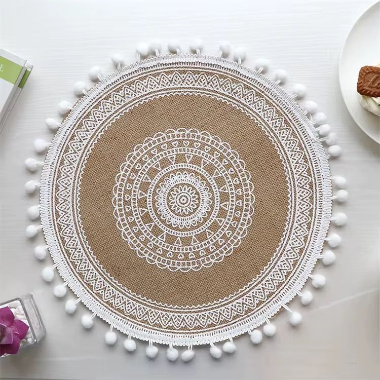 Beautiful round woven table mat with lace detail and pom-pom edges